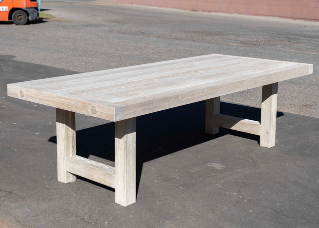 Wooden table on a concrete surface with a forklift in the background