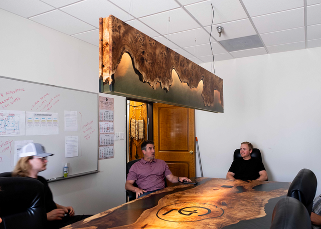 People sitting around a wooden table in an office setting with a decorative light
Image taken by Haley Knoke