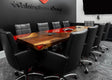Conference room with a wooden table and black chairs, featuring the Walsingham Group logo on the wall.