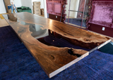 Wooden dining table with a natural finish on a blue carpeted floor.